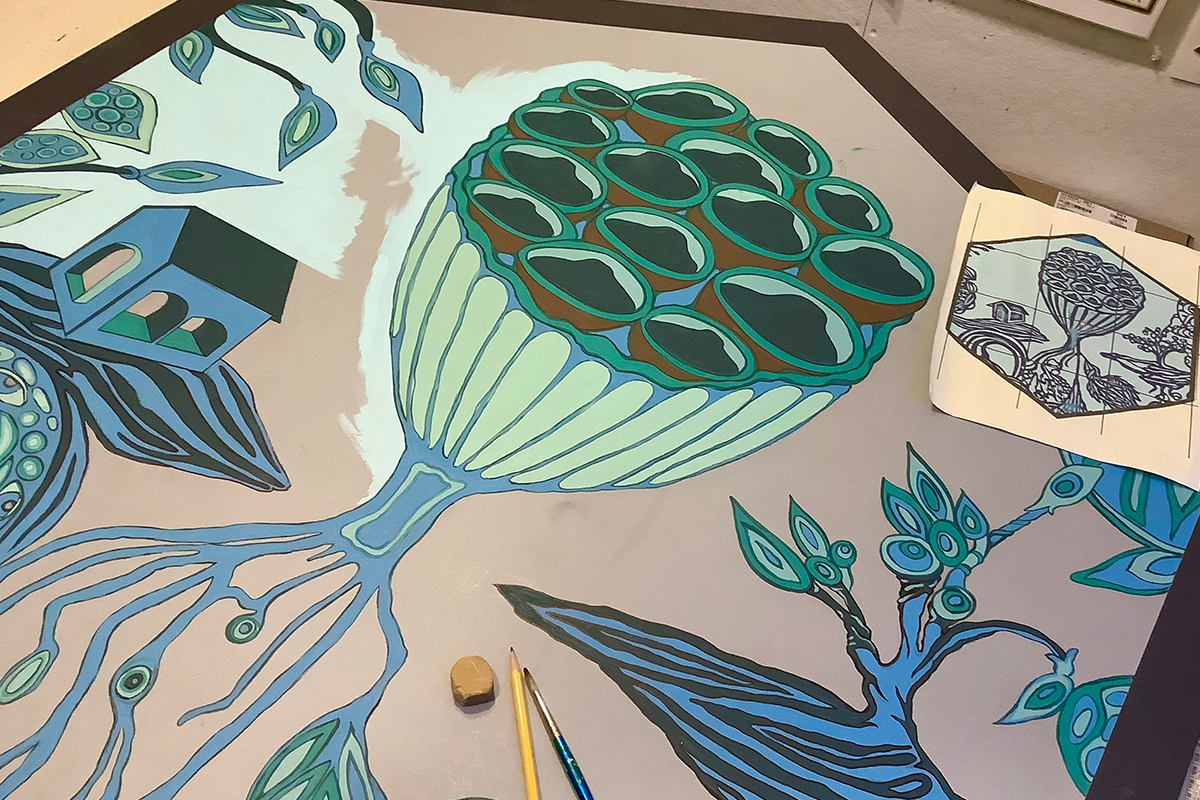 A panel depicting green and blue foliage besides a house