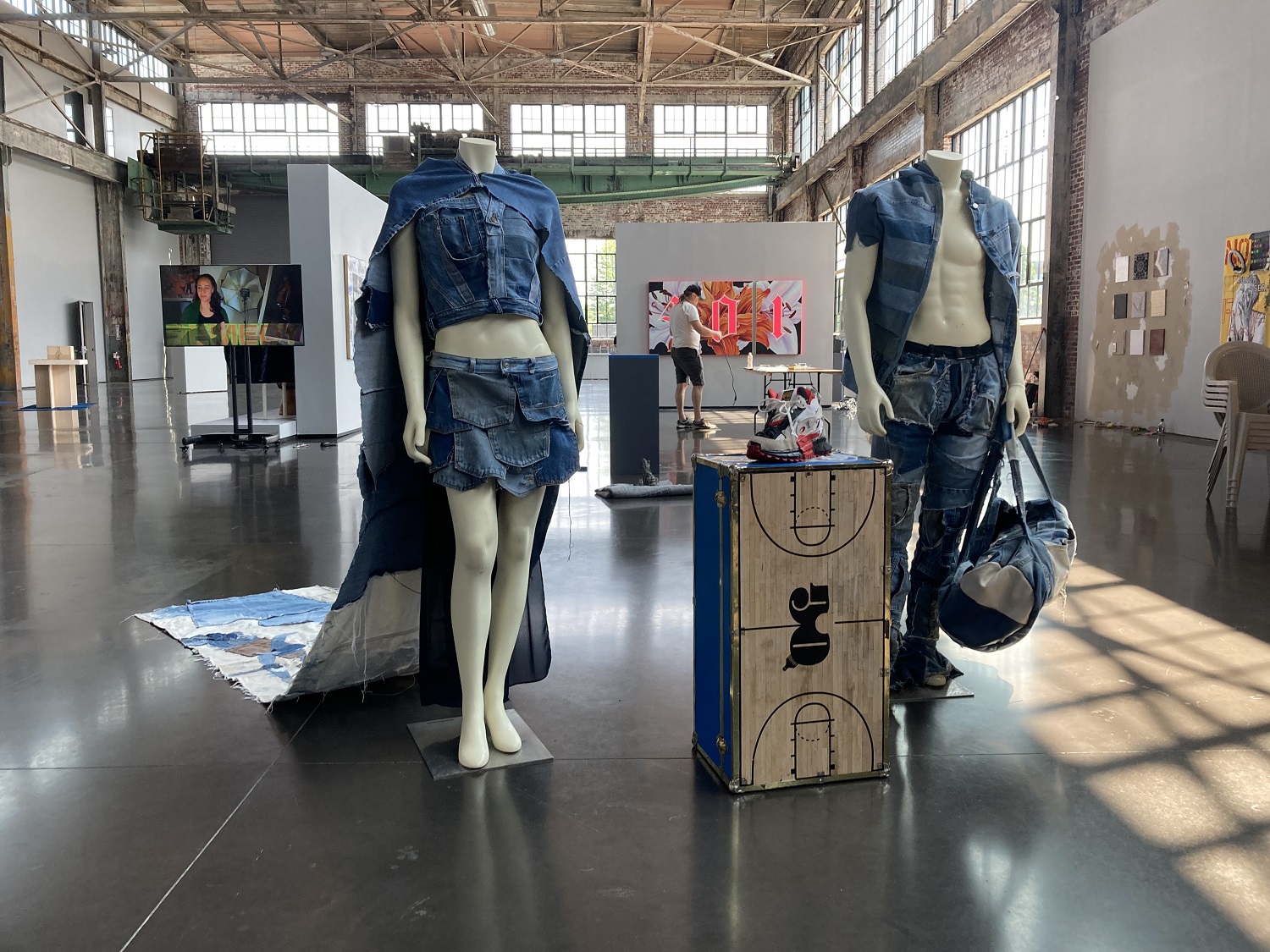 Two denim outfits on mannequins in an exhibition hall