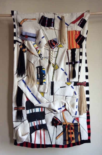 A white wool tapestry marked with acrylic paint in multiple colors