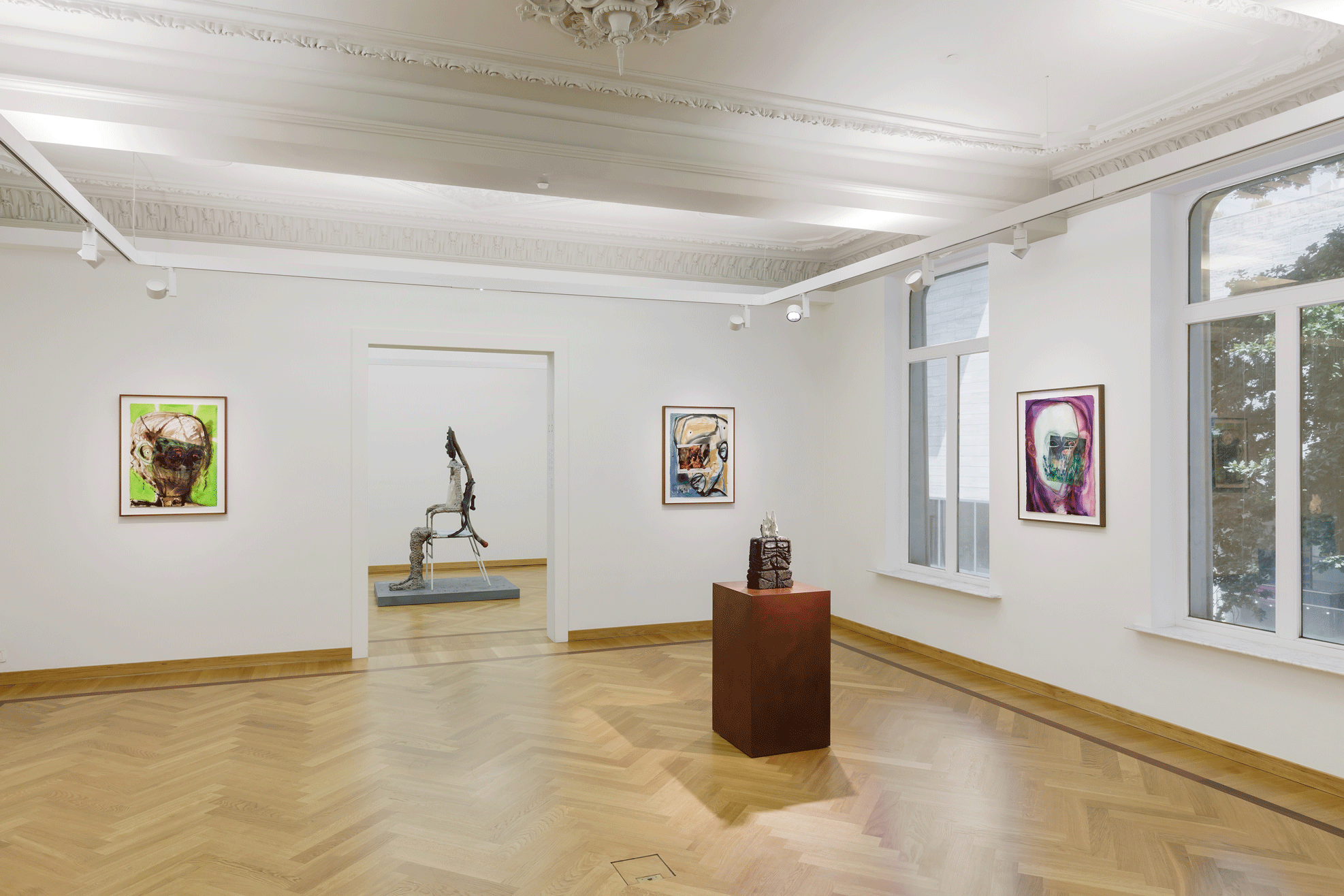 Two sculptures and three paintings in a gallery