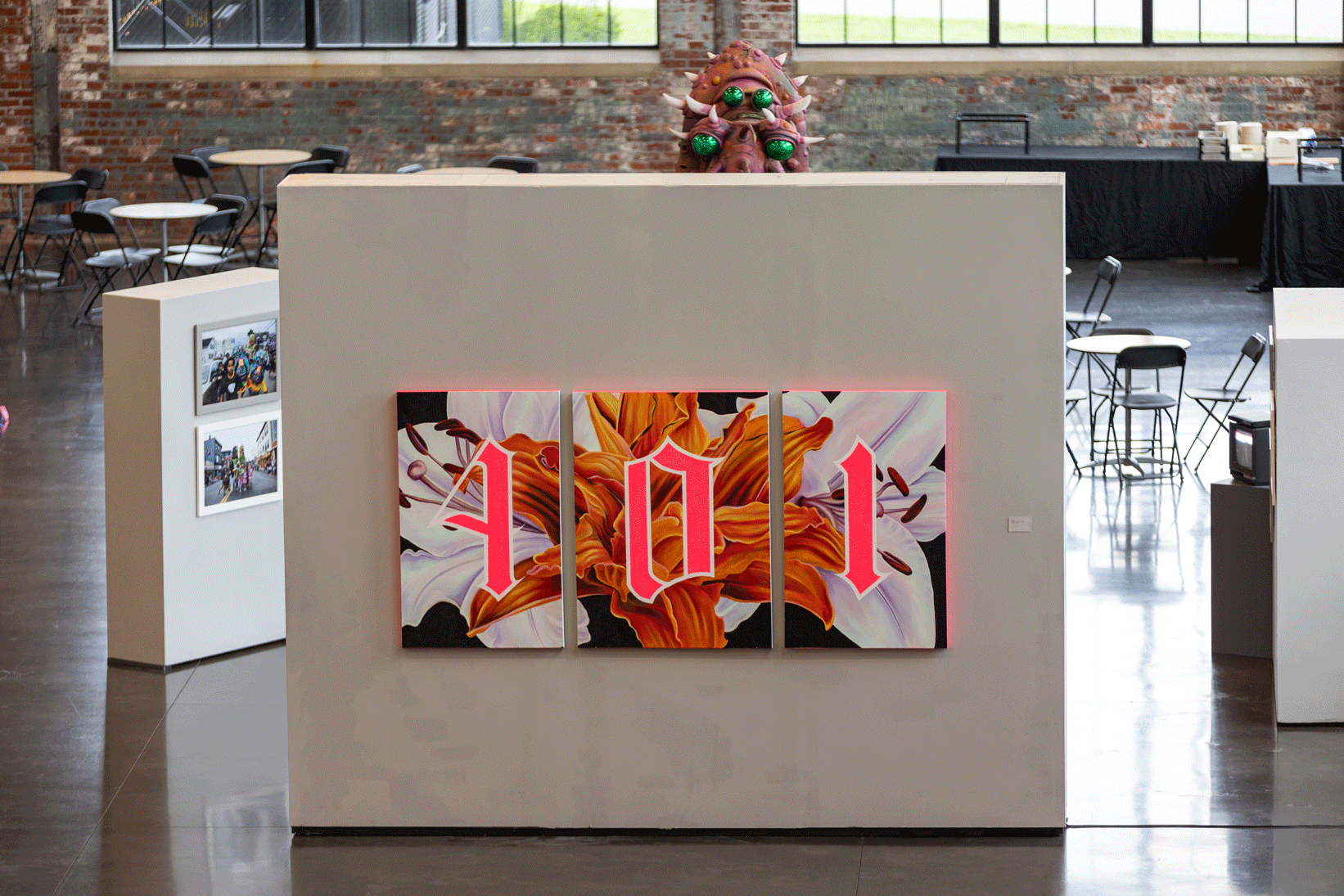 A print of a flower and the number "401" in neon pink paint divided across three canvases