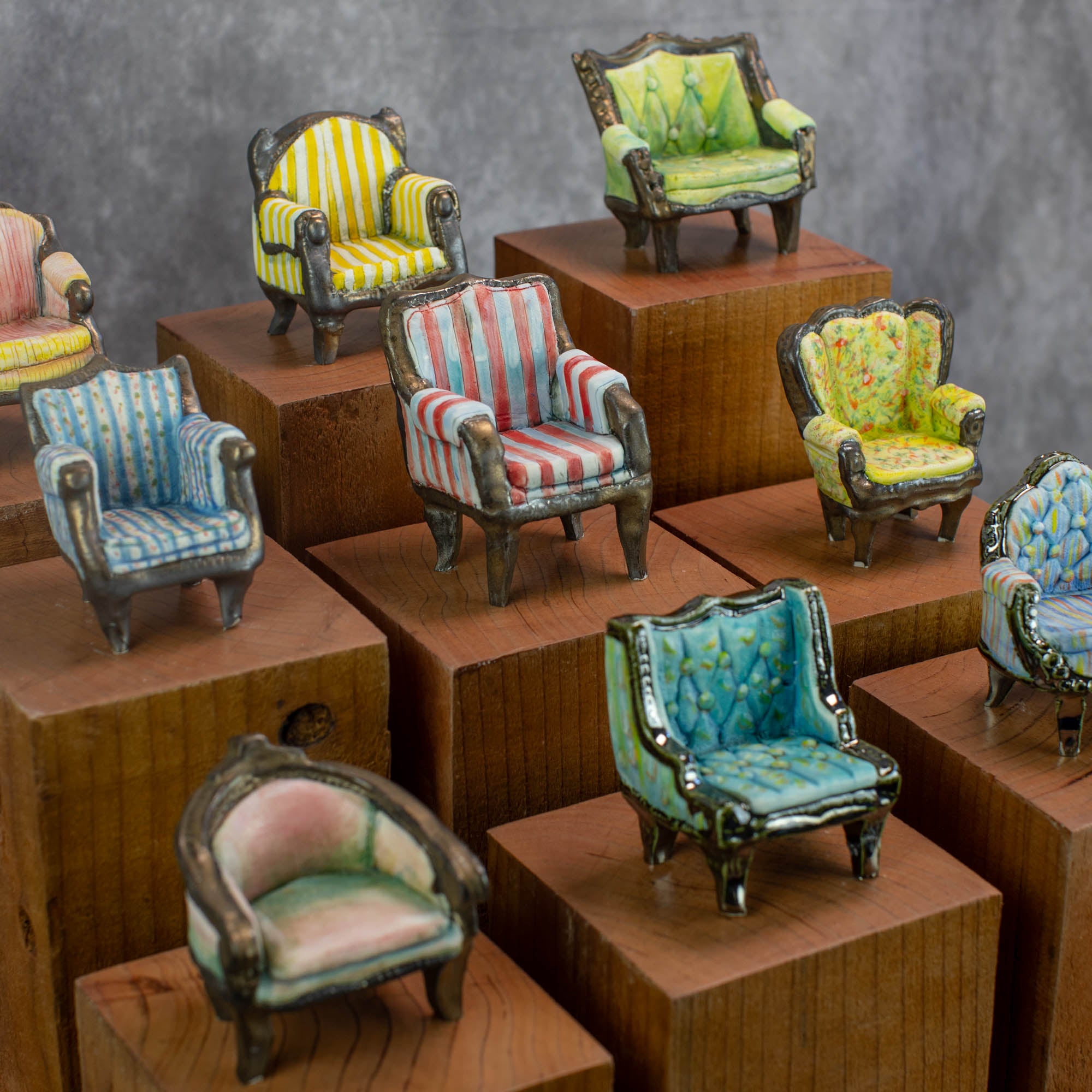 A display of nine palm-sized porcelain chairs