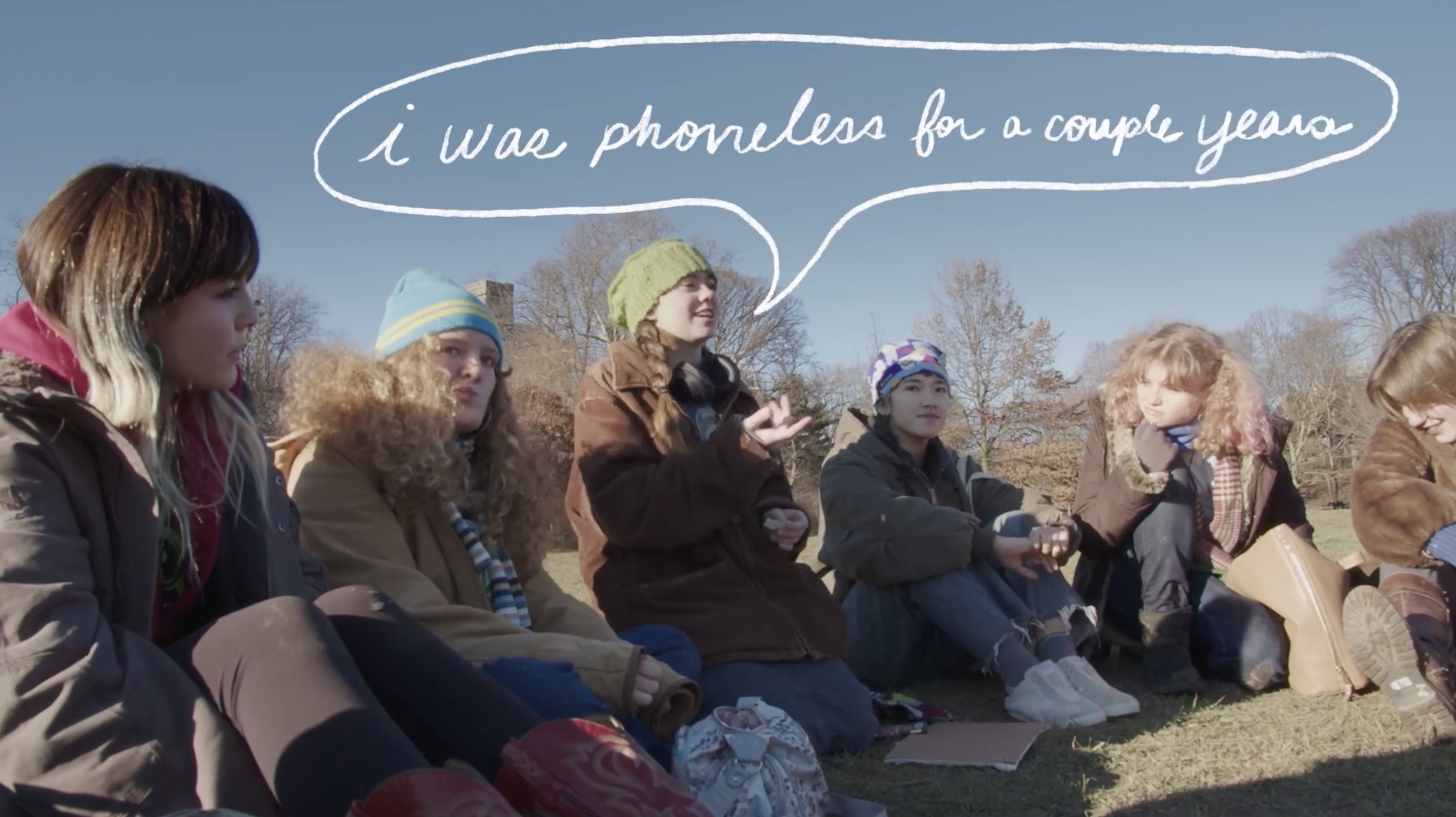 Students sitting outside in coats and hats