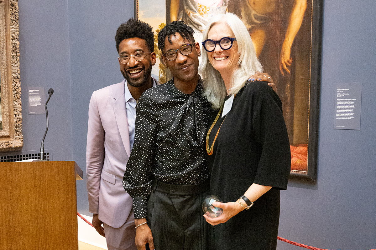 Jon and Jarrett Key stand with Elizabeth Whelan in front of an old master painting in the grand gallery of the RISD Museum