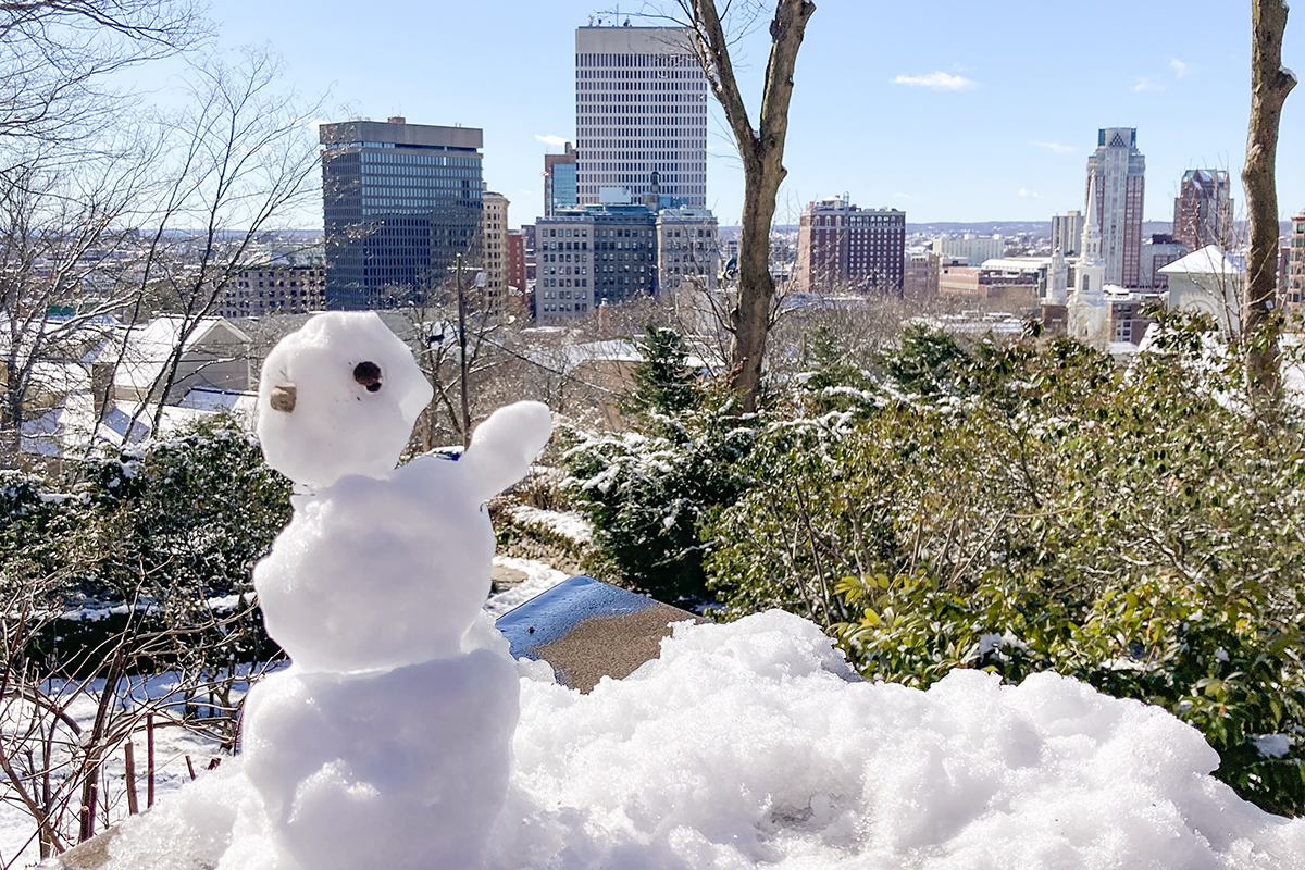 Small snow figure with Providence as a backdrop 