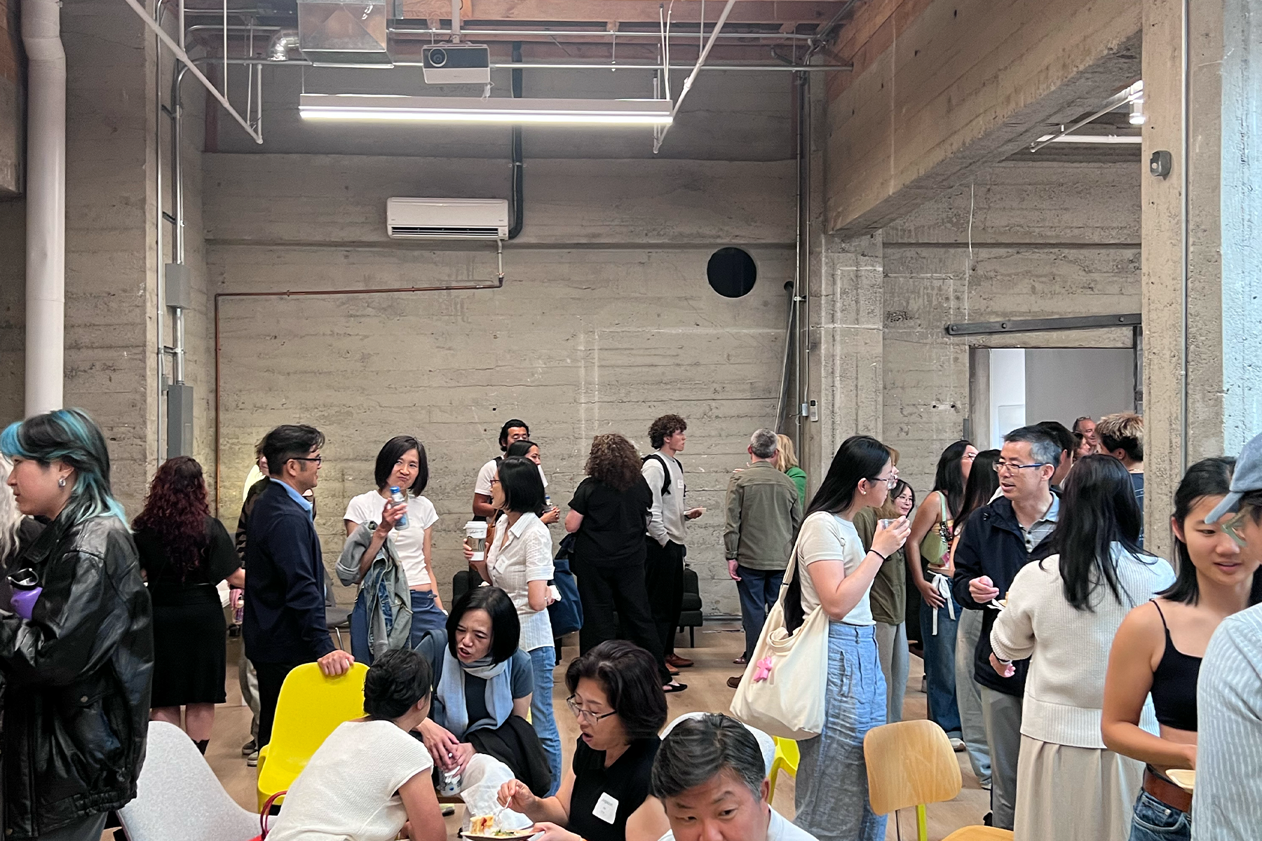 RISD Community Members gathered in an industrial style space