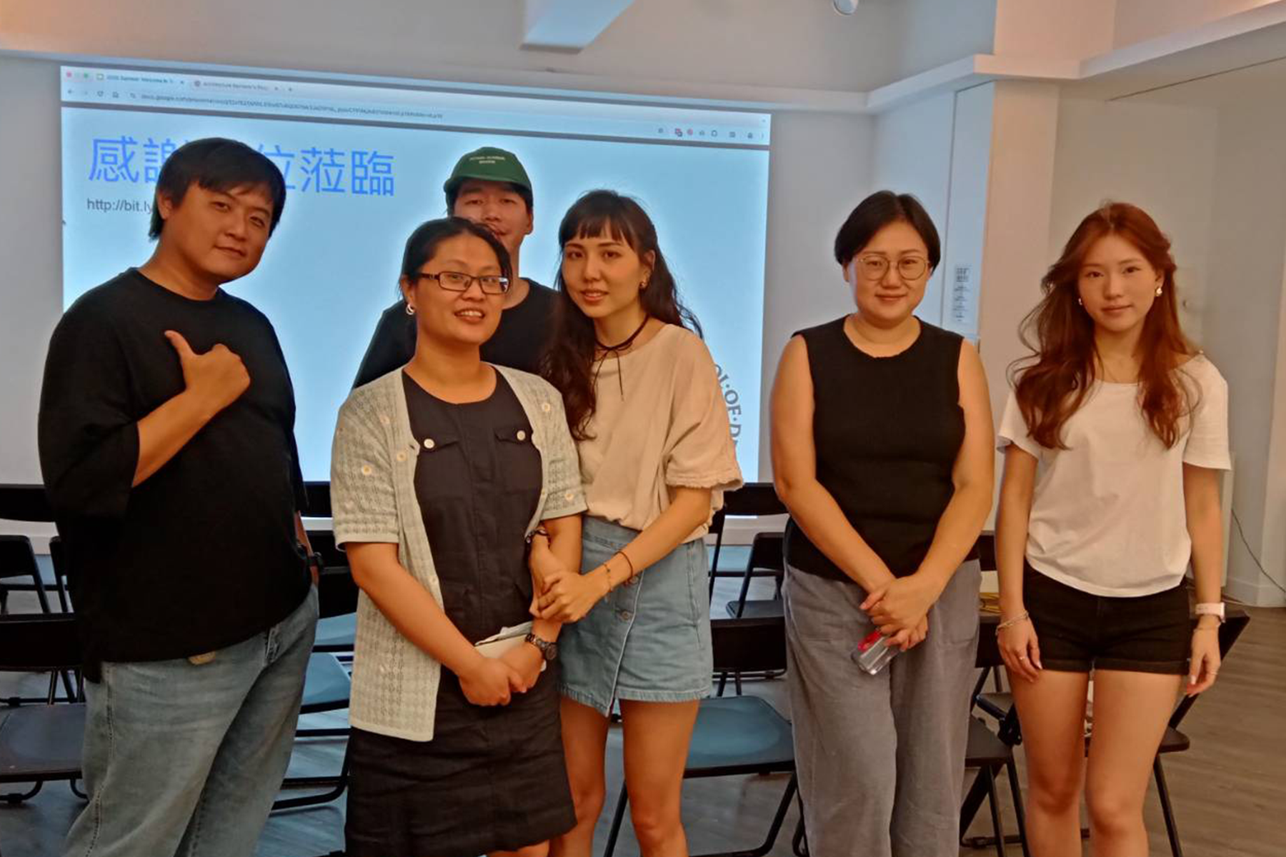 RISD Community members posed in front of a screen