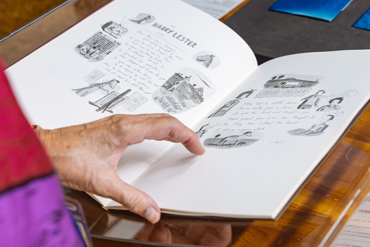 Person looking at a sketchbook in an archive setting